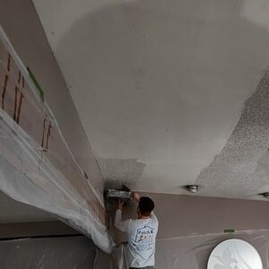 Painter skimming over textured ceiling